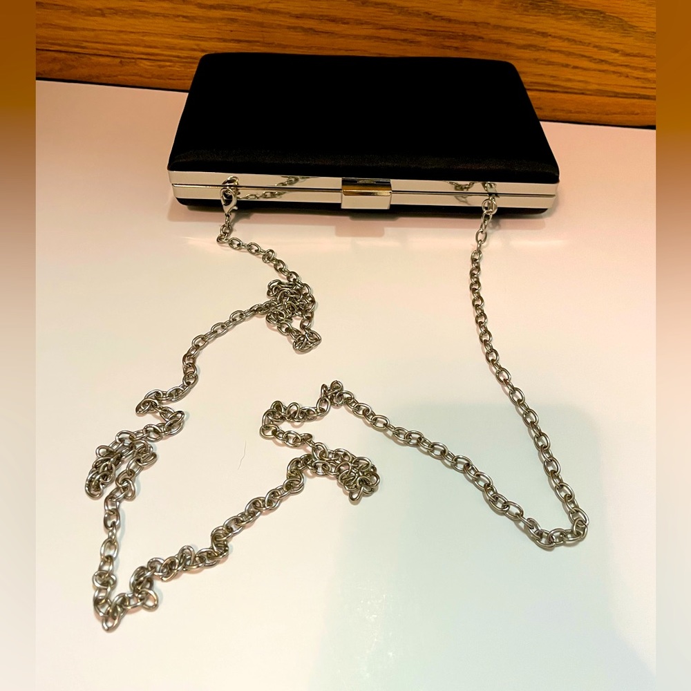 Black Satin clutch/purse. Silver tone removable chain strap.